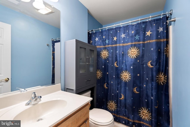 bathroom featuring curtained shower, vanity, and toilet