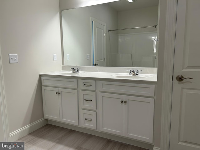 bathroom featuring vanity, a shower, and wood-type flooring