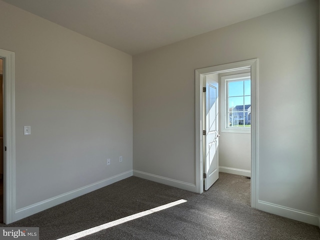 unfurnished bedroom with dark carpet