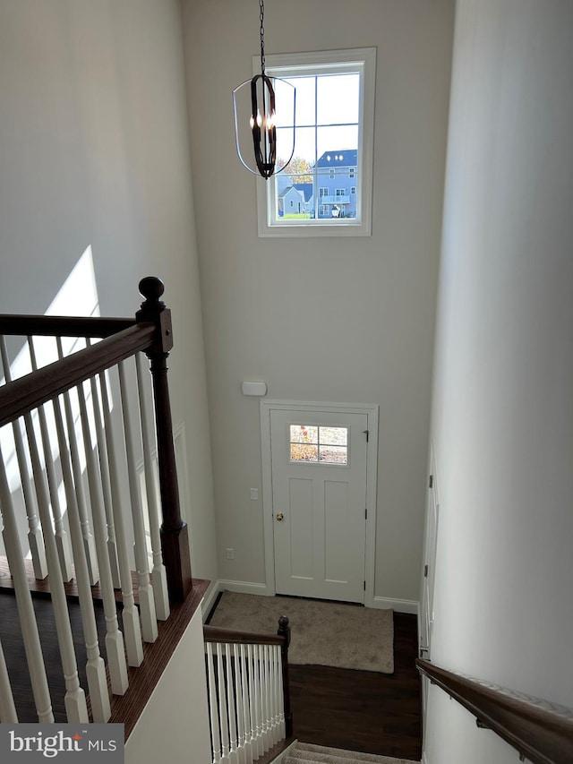 entryway featuring dark hardwood / wood-style flooring and a chandelier