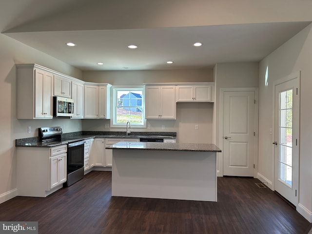 kitchen with white cabinets, dark hardwood / wood-style floors, a healthy amount of sunlight, and stainless steel appliances