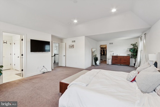 bedroom with a spacious closet, light carpet, and a closet