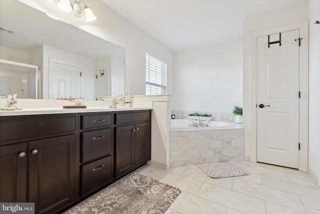 bathroom with vanity and shower with separate bathtub