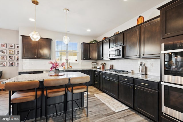 kitchen with dark brown cabinets, a center island, and stainless steel appliances