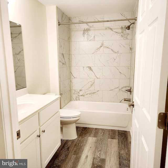 full bathroom featuring toilet, vanity, tiled shower / bath combo, and hardwood / wood-style flooring