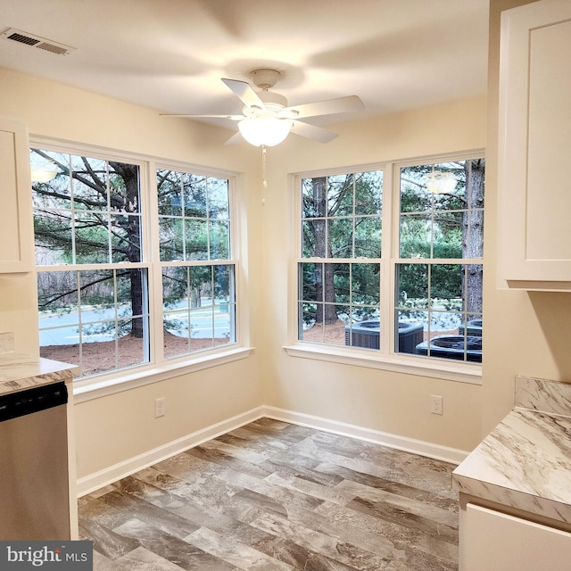 unfurnished dining area featuring ceiling fan, plenty of natural light, and hardwood / wood-style floors