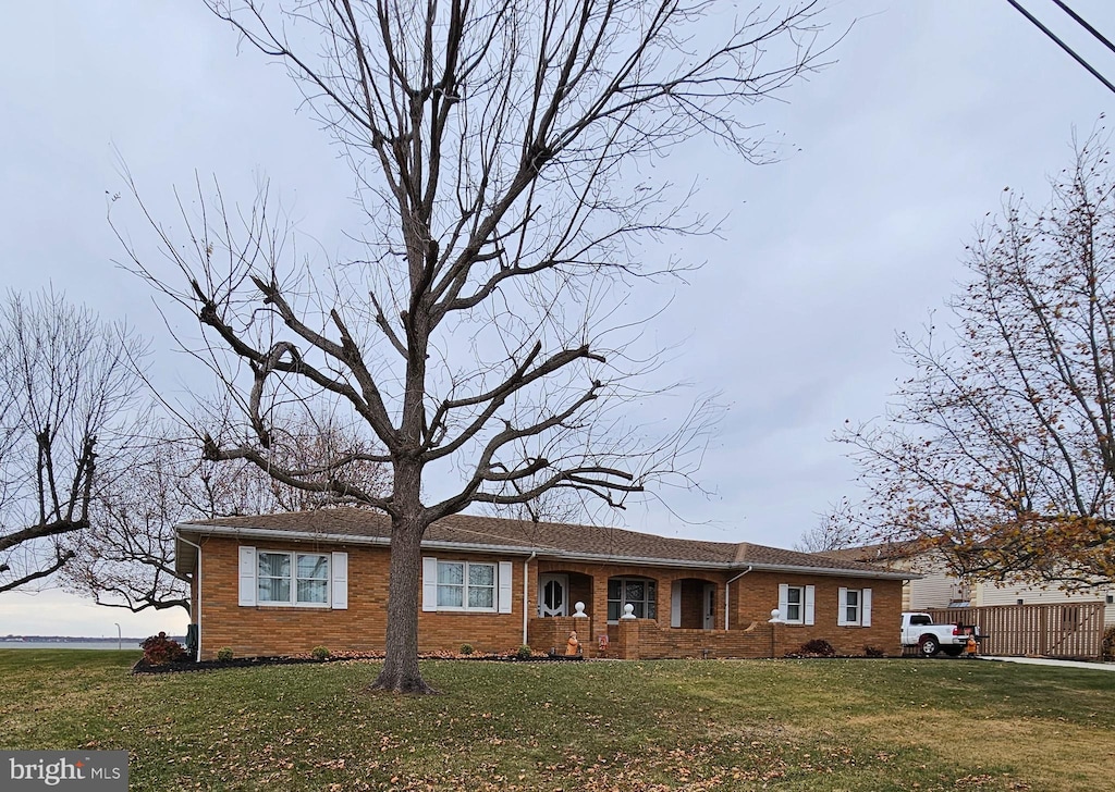 ranch-style home featuring a front lawn