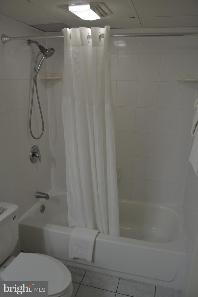 bathroom with tile patterned floors, toilet, and shower / tub combo with curtain