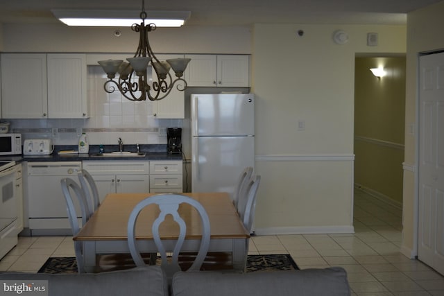 kitchen with white cabinetry, sink, decorative light fixtures, white appliances, and decorative backsplash