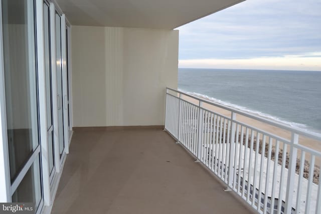 balcony with a water view and a beach view