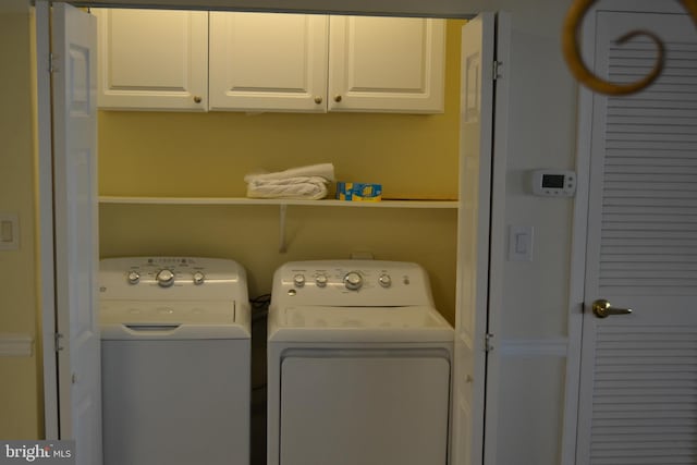 laundry area featuring washer and dryer and cabinets