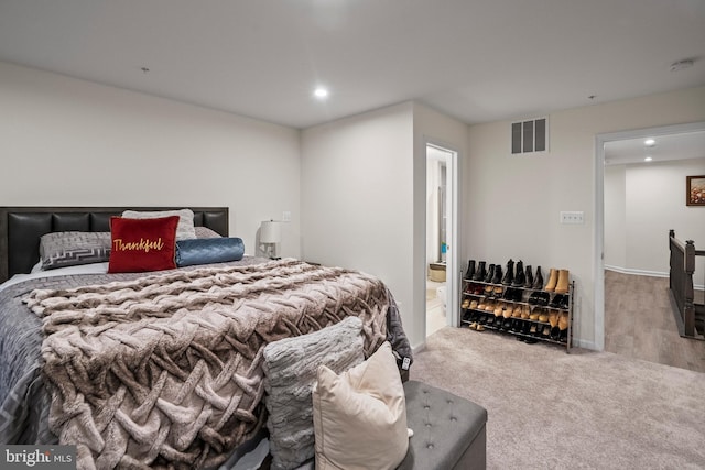 bedroom featuring light wood-type flooring and connected bathroom