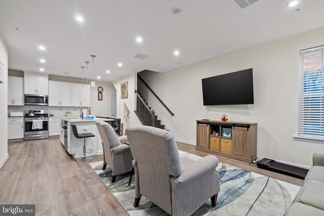 living room featuring light wood-type flooring and sink