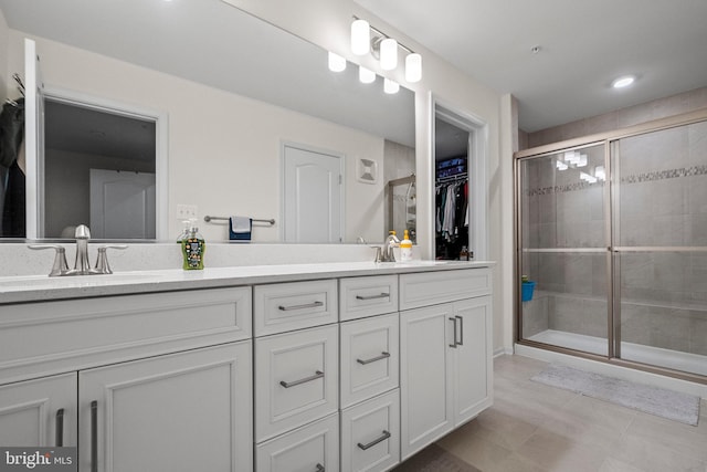 bathroom featuring tile patterned flooring, vanity, and a shower with shower door