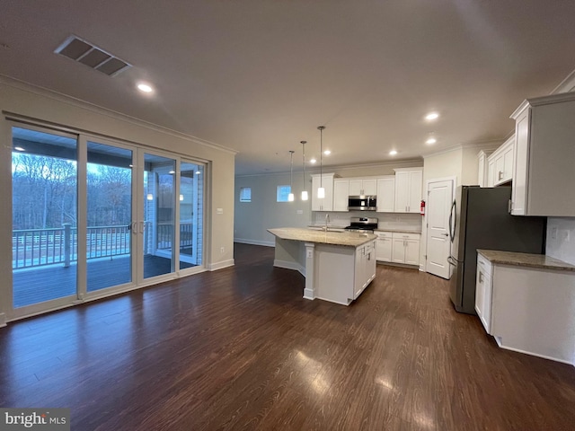 kitchen with sink, stainless steel appliances, dark hardwood / wood-style floors, decorative light fixtures, and a kitchen island with sink