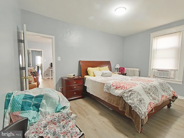 bedroom featuring light hardwood / wood-style floors and radiator heating unit