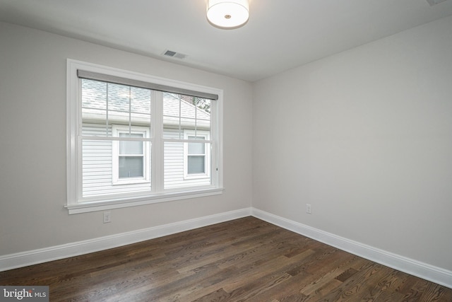 unfurnished room with dark hardwood / wood-style flooring