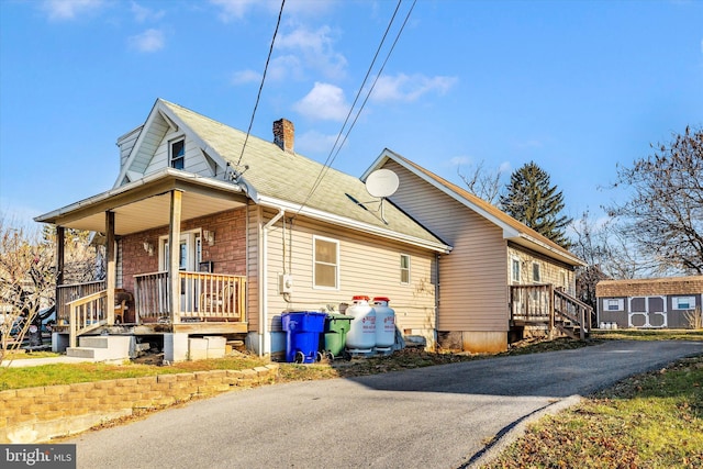 view of front of house with a porch and a storage unit