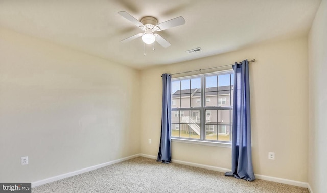 carpeted spare room with ceiling fan