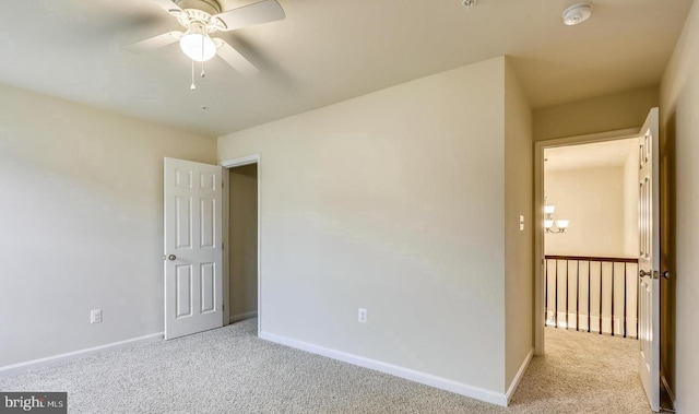 carpeted spare room featuring ceiling fan