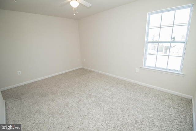 carpeted spare room featuring ceiling fan