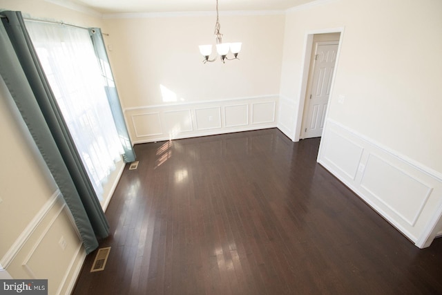 unfurnished dining area with dark wood-type flooring, a notable chandelier, and ornamental molding