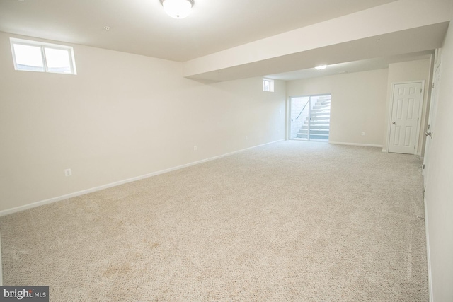 basement featuring light colored carpet and plenty of natural light