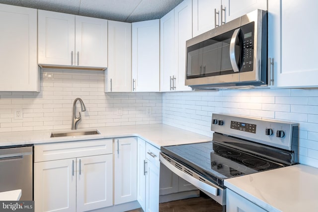 kitchen featuring a sink, light countertops, white cabinetry, and stainless steel appliances