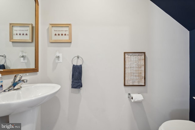 bathroom featuring sink and lofted ceiling