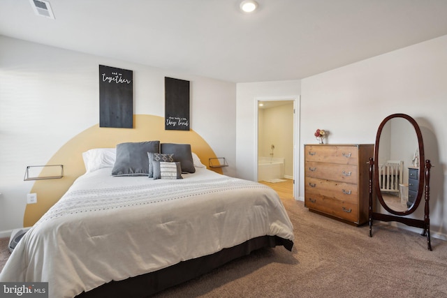 bedroom with carpet floors and connected bathroom