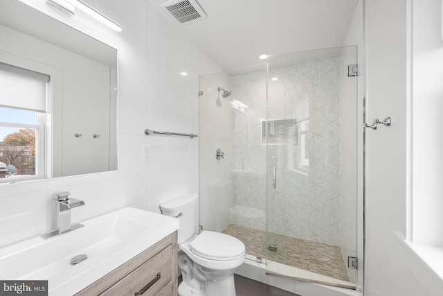 bathroom featuring vanity, toilet, and a shower with door