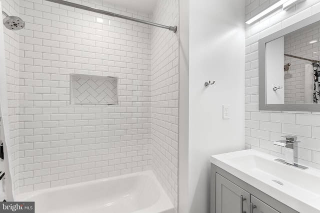 bathroom featuring tasteful backsplash, vanity, and tiled shower / bath combo