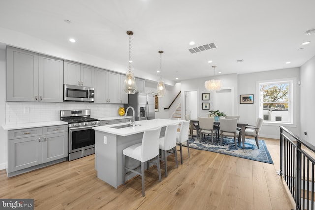 kitchen featuring gray cabinets, sink, light hardwood / wood-style floors, and stainless steel appliances