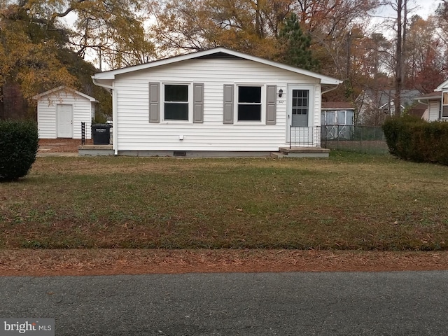 view of front of home featuring a storage unit and a front yard