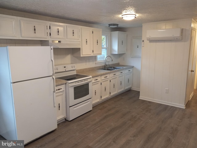 kitchen with sink, dark hardwood / wood-style floors, a wall mounted AC, white appliances, and white cabinets