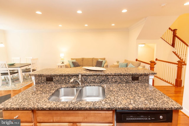 kitchen featuring crown molding, sink, stone countertops, light hardwood / wood-style flooring, and black dishwasher