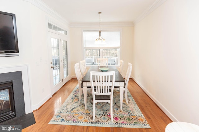 dining space with hardwood / wood-style floors, french doors, and crown molding