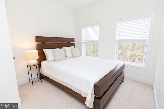 carpeted bedroom featuring multiple windows