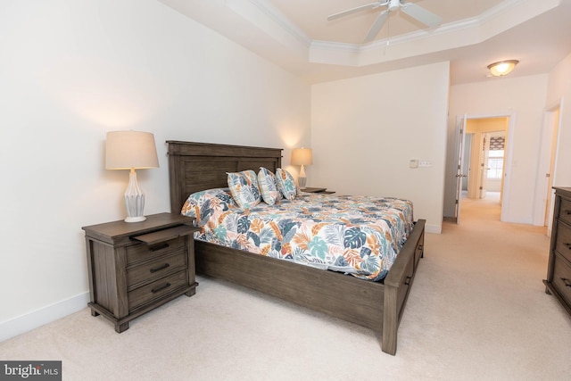 carpeted bedroom featuring ceiling fan, crown molding, and a tray ceiling