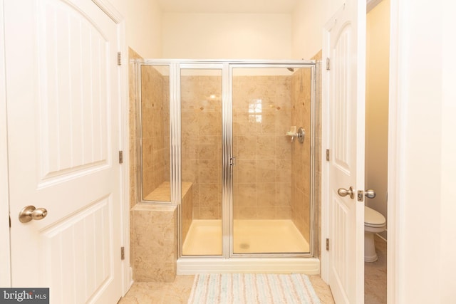 bathroom with tile patterned floors, toilet, and walk in shower