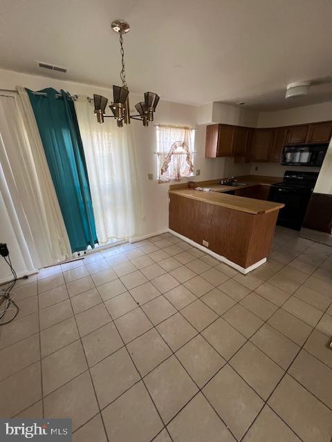 kitchen with sink, hanging light fixtures, kitchen peninsula, light tile patterned flooring, and black appliances