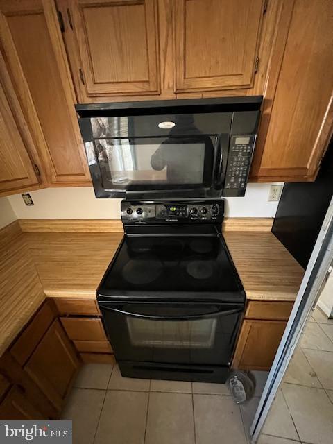 kitchen featuring light tile patterned floors and black appliances