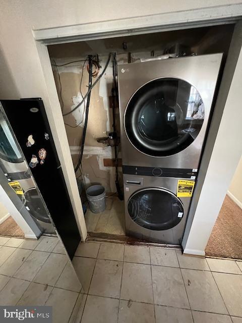 washroom featuring light tile patterned floors and stacked washer / drying machine