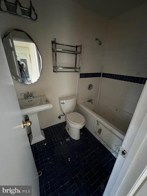 full bathroom featuring sink, washtub / shower combination, and toilet