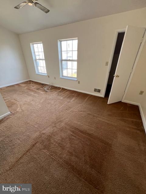 carpeted spare room with ceiling fan