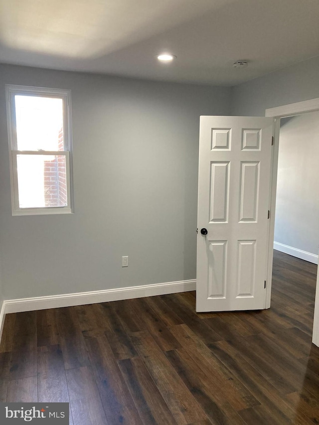 spare room featuring dark wood-type flooring