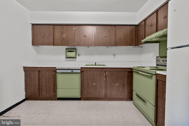 kitchen with dark brown cabinetry, sink, and white appliances