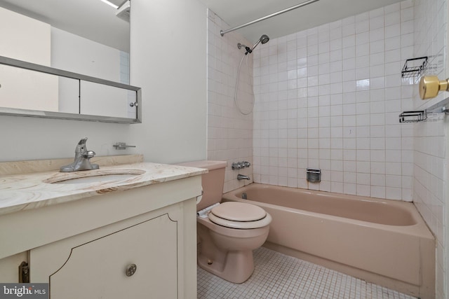 full bathroom with tile patterned floors, tiled shower / bath, vanity, and toilet