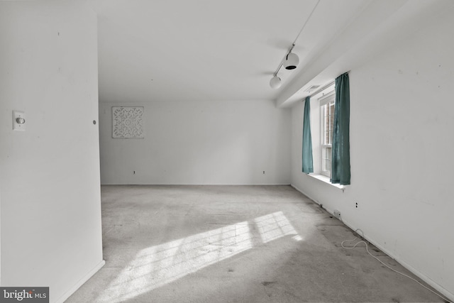 carpeted spare room featuring track lighting