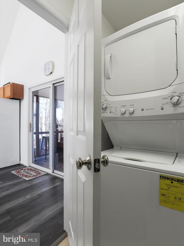 laundry area featuring stacked washer / drying machine and wood-type flooring